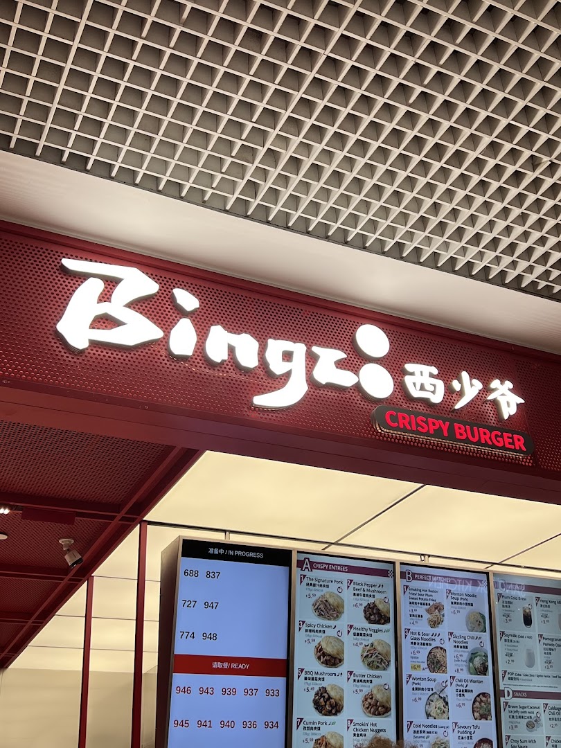 A vibrant shot of Bingz Singapore's counter, featuring its illuminated sign, digital order screen, and menu.