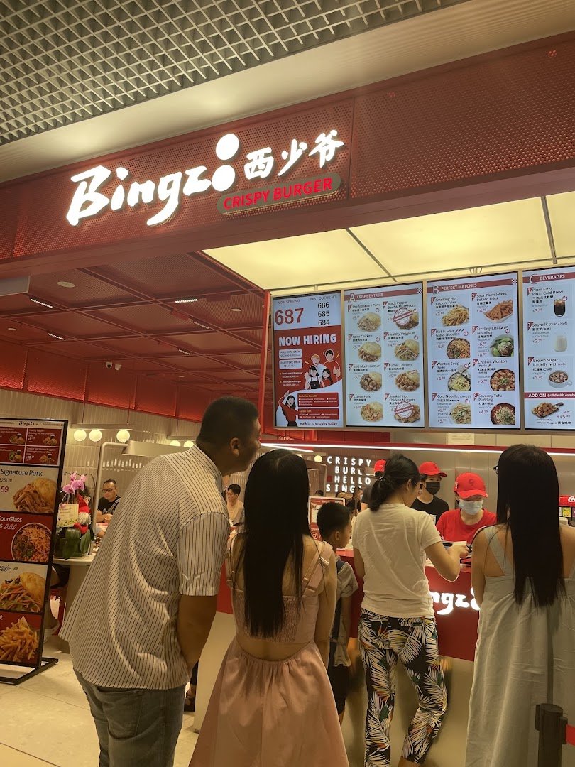 Customers queueing at the counter of Bingz Crispy Burger, with menu boards displaying food and beverage options.