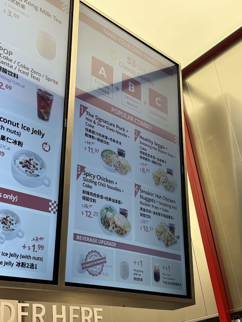 A digital menu board displaying various food and drink combos, including popular meals and beverage upgrades.