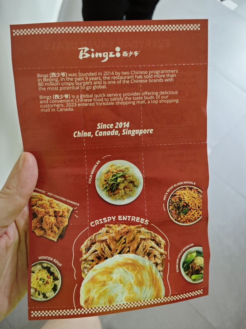 A close-up of Bingz Singapore's vibrant red menu, showcasing their signature crispy entrees and noodle dishes.