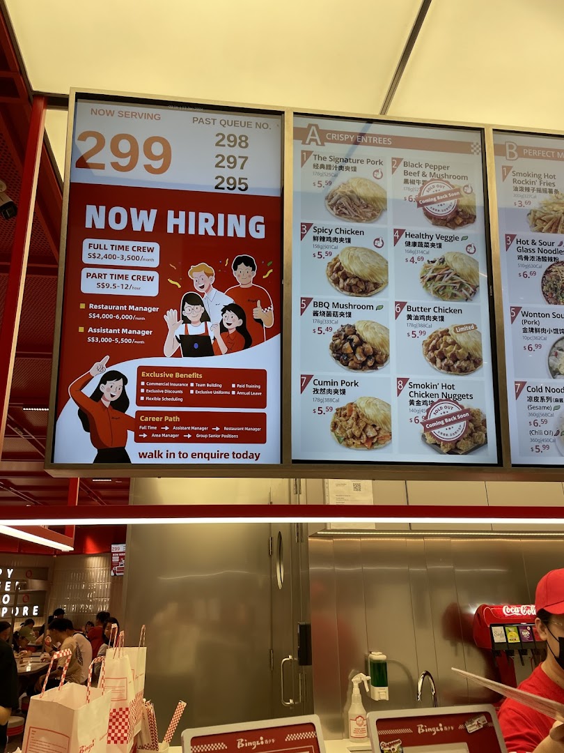 Digital menu boards display crispy entrees, sides, and a 'Now Hiring' advertisement inside Bingz Singapore.
