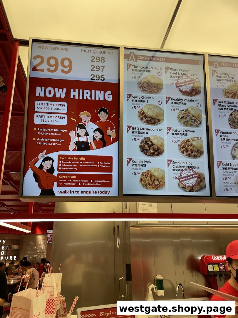 Digital menu boards display crispy entrees, sides, and a 'Now Hiring' advertisement inside Bingz Singapore.