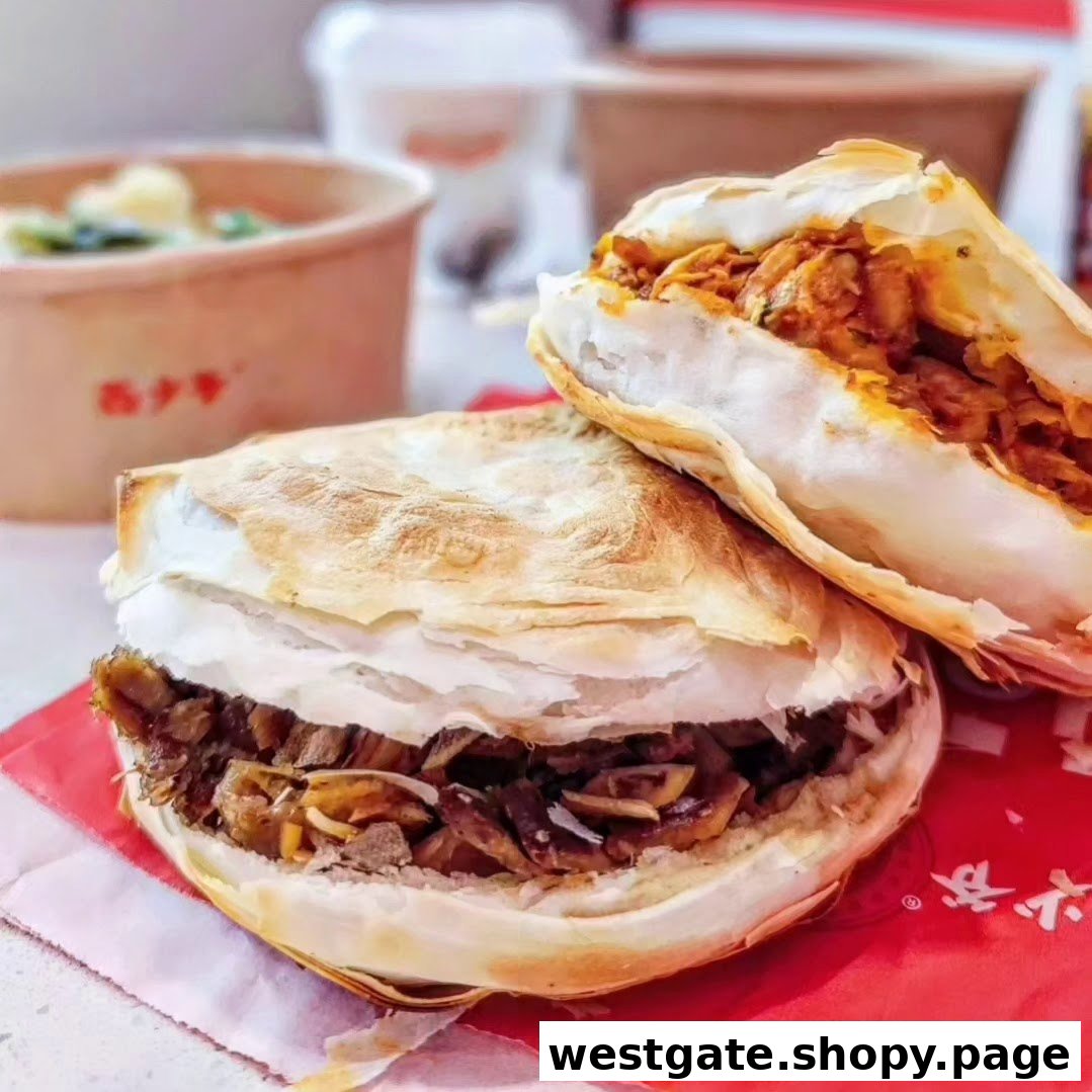 Two delicious Bingz roujiamo, one with meat and another filling, served on a red paper.