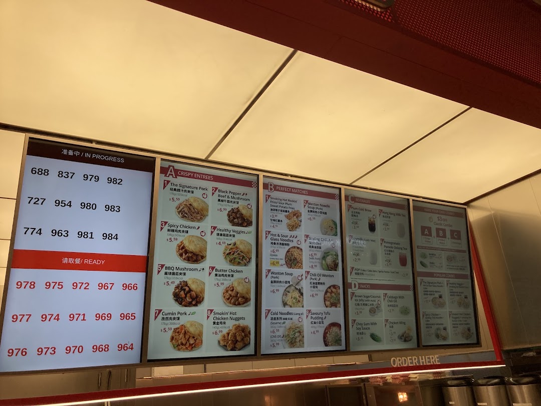 A digital menu board displaying various Chinese street food items, beverages, and combo deals, alongside a queue number system.