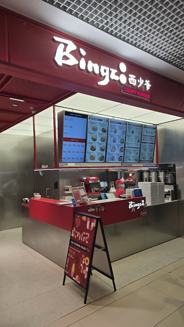 A vibrant red counter and digital menu boards at Bingz Singapore, showcasing their modern fast-casual setup.