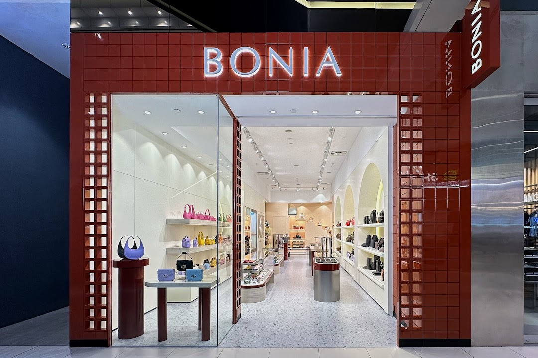 The vibrant red storefront of Bonia, showcasing a wide array of stylish handbags and accessories.