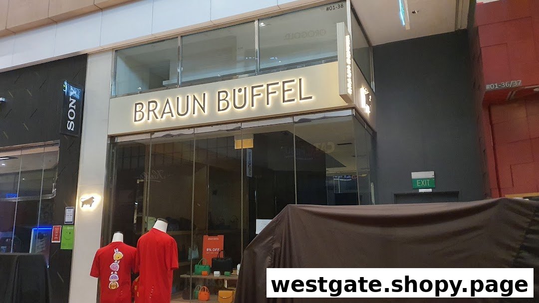 The illuminated storefront of Braun Büffel, showcasing luxury leather goods and a sale promotion.