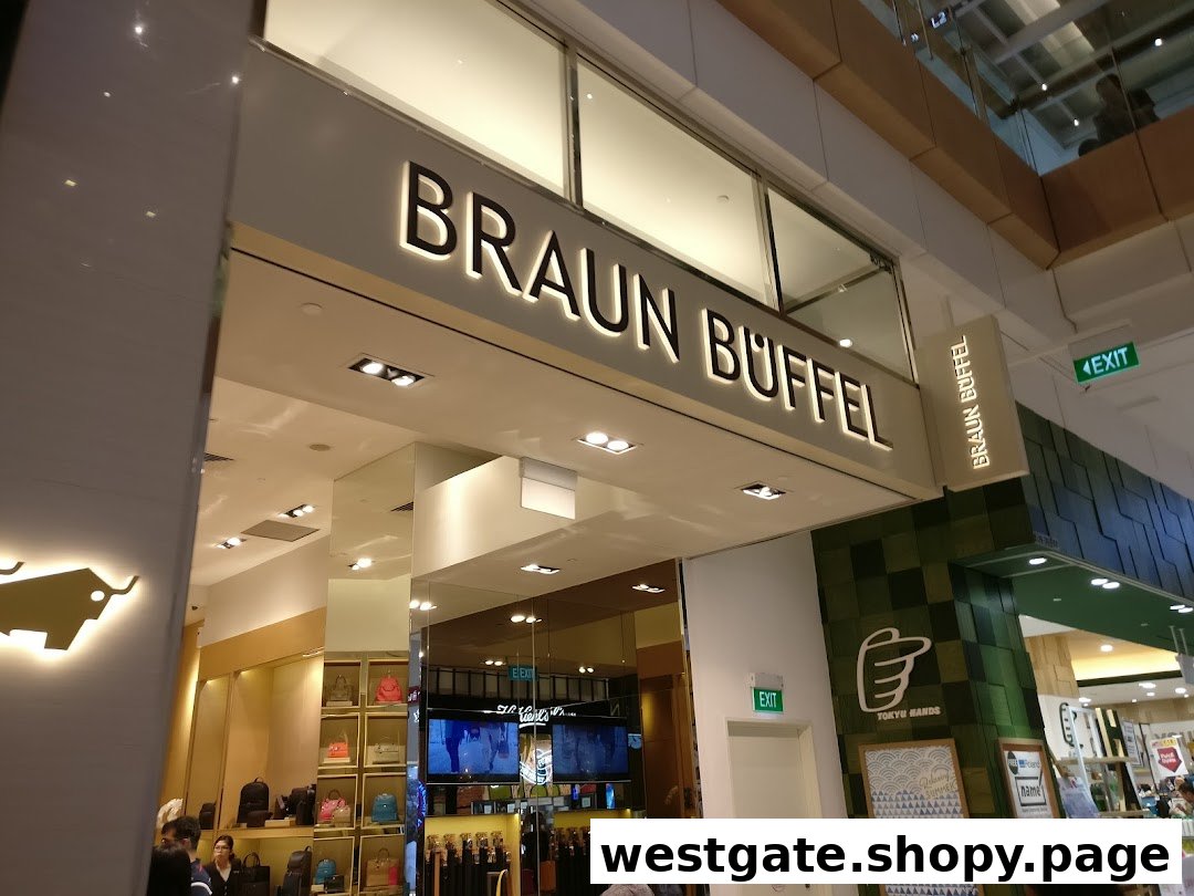 The illuminated entrance and storefront of the Braun Büffel luxury leather goods shop in a mall.
