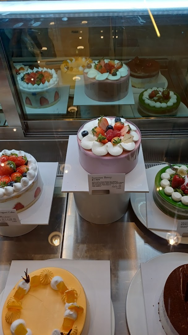 A vibrant display case showcasing a variety of beautifully decorated cakes at BreadTalk.