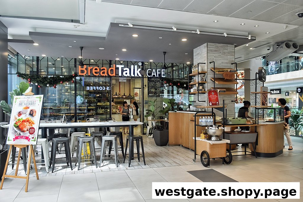 The inviting entrance of BreadTalk Cafe at Westgate, featuring seating and festive decor.