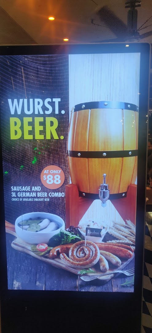 A digital display advertising a 'Wurst. Beer.' combo with sausages, a beer barrel, and an $88 price.