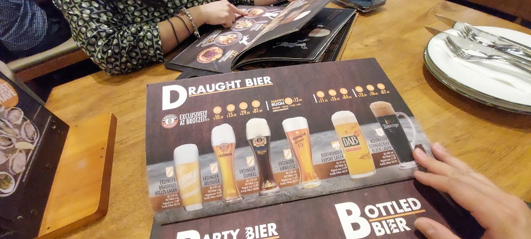 A close-up of a menu displaying various draught beers and their prices at Brotzeit German Beer Bar.