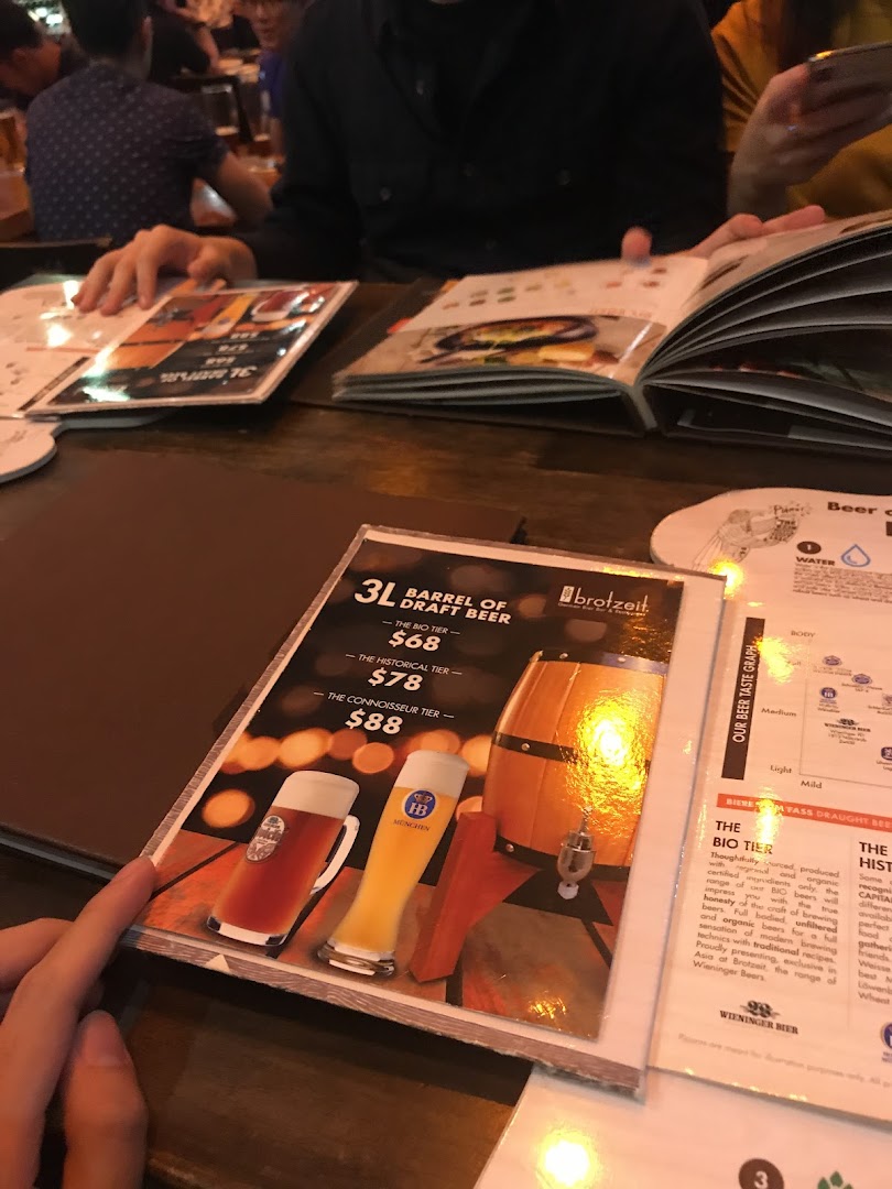 A close-up of a Brotzeit menu displaying a 3L barrel of draft beer promotion.
