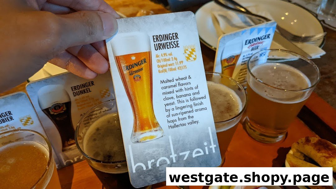 A hand holding a beer information card with several beer glasses and food on a table.