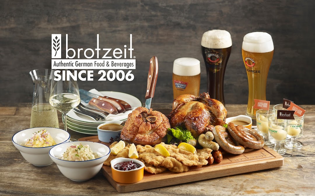 A lavish spread of authentic German dishes, including pork knuckle, schnitzel, sausages, and roasted chicken, with German beers and wine.