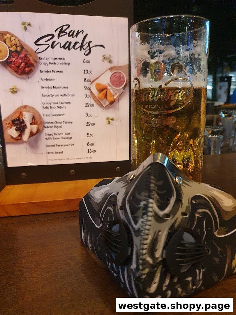A menu stand displaying 'Bar Snacks' with prices, next to a glass of beer and a face mask.