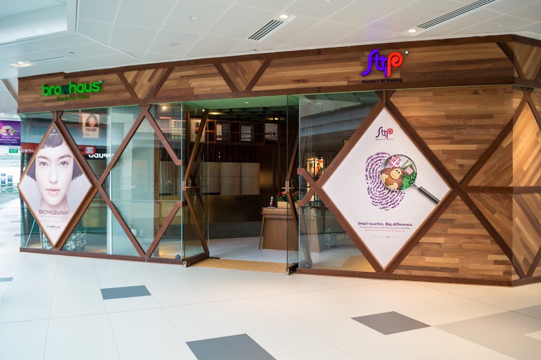 The exterior of Browhaus and Strip, featuring a modern design with wood and glass, showcasing beauty services.