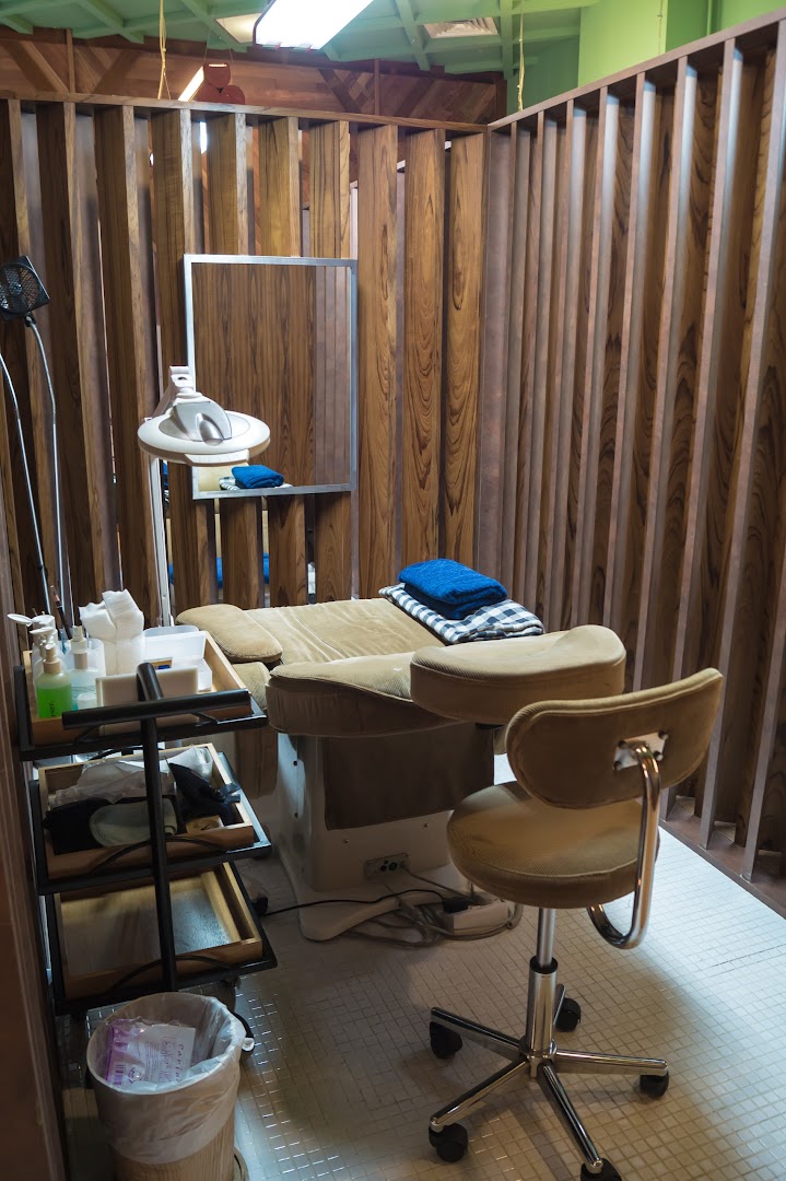 A cozy treatment room at Browhaus, featuring a comfortable bed, adjustable chair, and professional equipment.