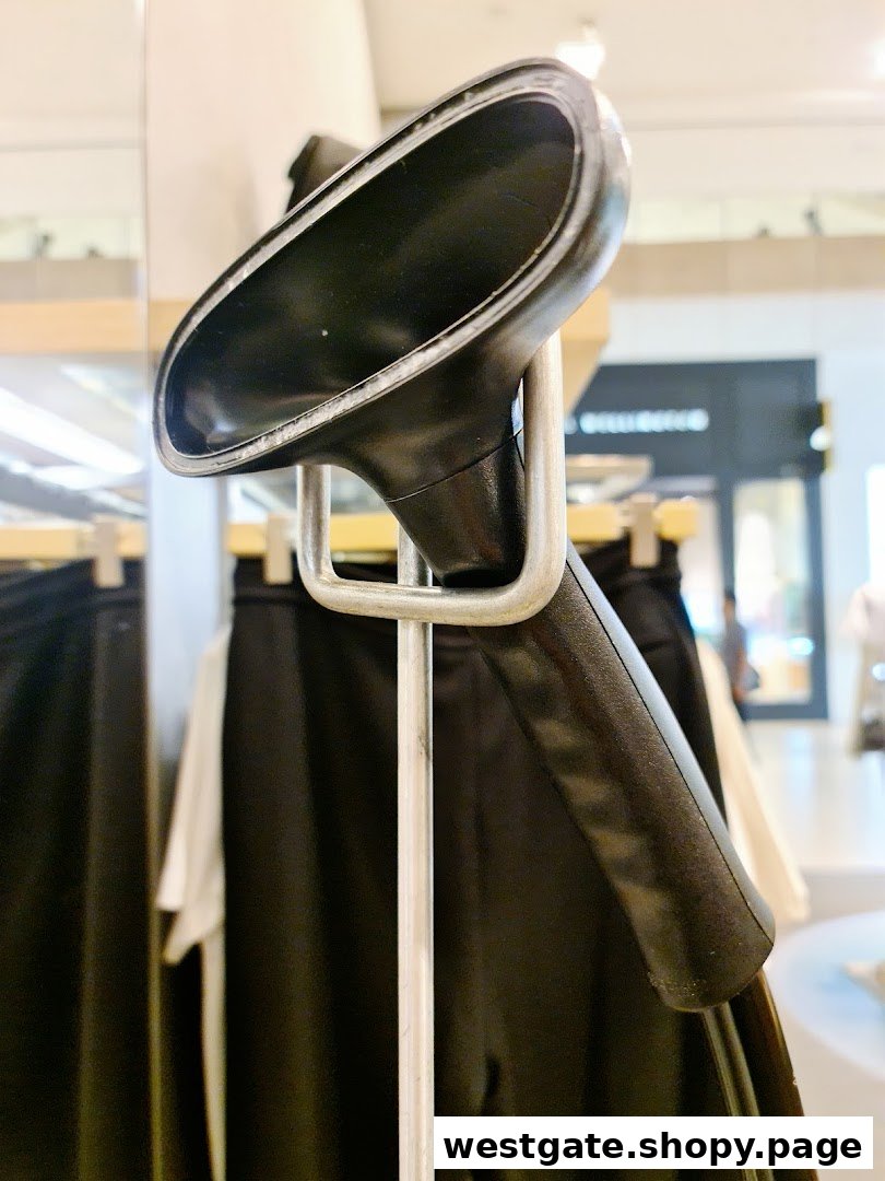 A close-up of a garment steamer in a Calvin Klein store, with clothing racks in the background.