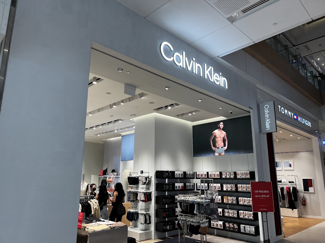 The Calvin Klein storefront showcases modern apparel, underwear, and accessories, featuring a large digital display and inviting interior.