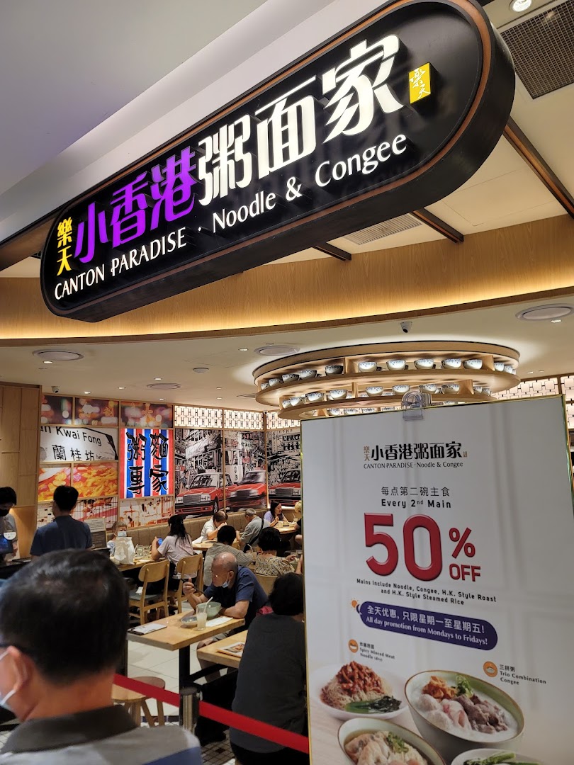 An inviting interior shot of Canton Paradise Noodle & Congee House, bustling with diners and featuring a promotional standee.