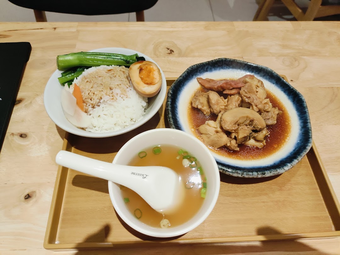 A delicious meal set featuring rice, braised meat, vegetables, a soy-marinated egg, and a clear soup.
