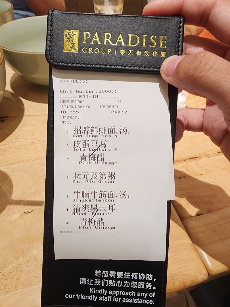 Close-up of a customer's order chit from Canton Paradise, listing various noodle, congee, and side dishes.
