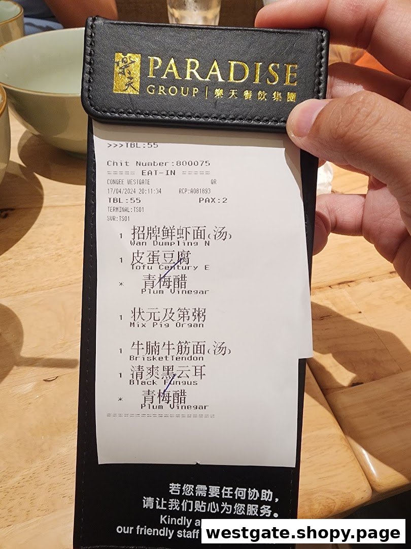 Close-up of a customer's order chit from Canton Paradise, listing various noodle, congee, and side dishes.