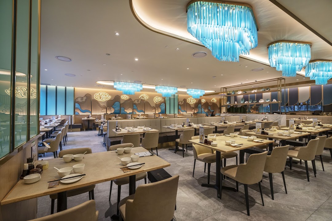 A spacious and elegantly decorated dining area with numerous tables, comfortable seating, and modern lighting fixtures.