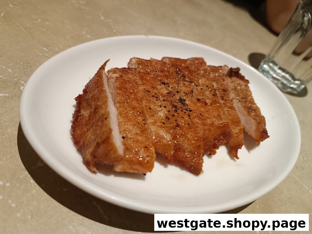 A plate of perfectly fried and sliced pork chop, seasoned with black pepper.