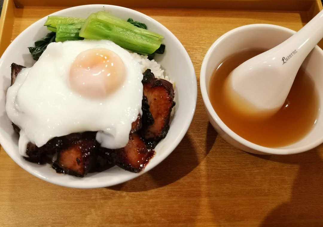 A delicious bowl of char siew rice with a fried egg and vegetables, served with a side of soup.