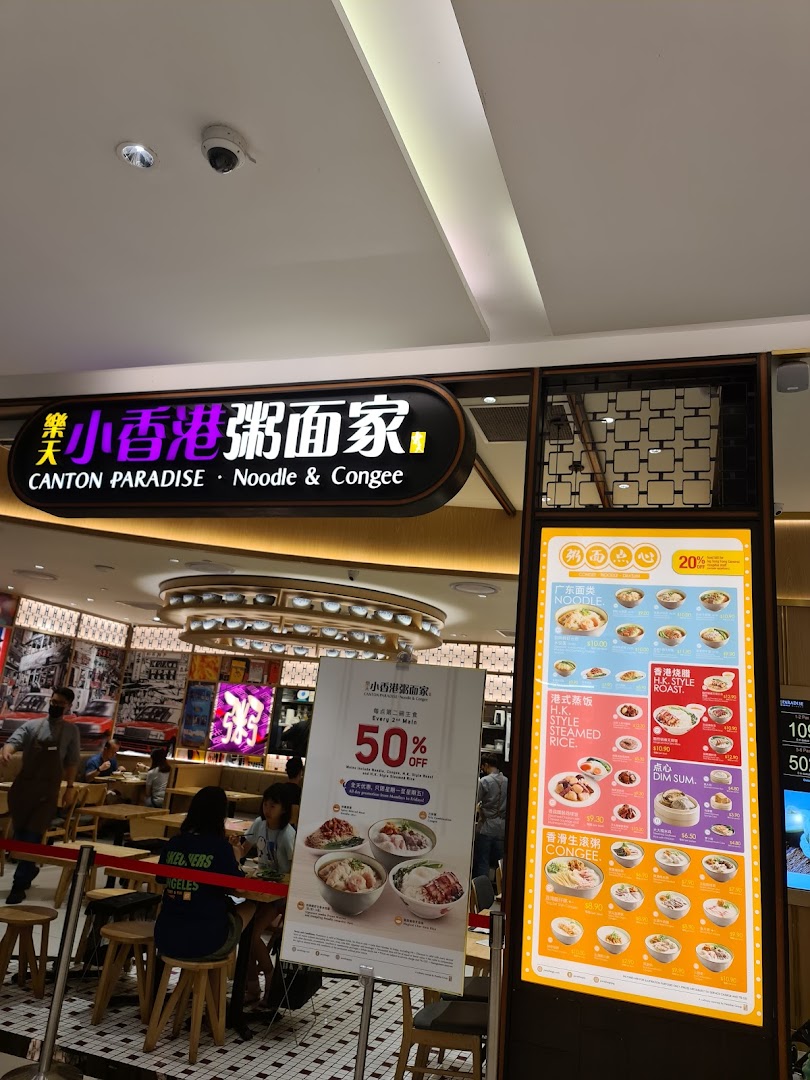 The vibrant entrance of Canton Paradise Noodle & Congee House, featuring its illuminated sign and a digital menu display.