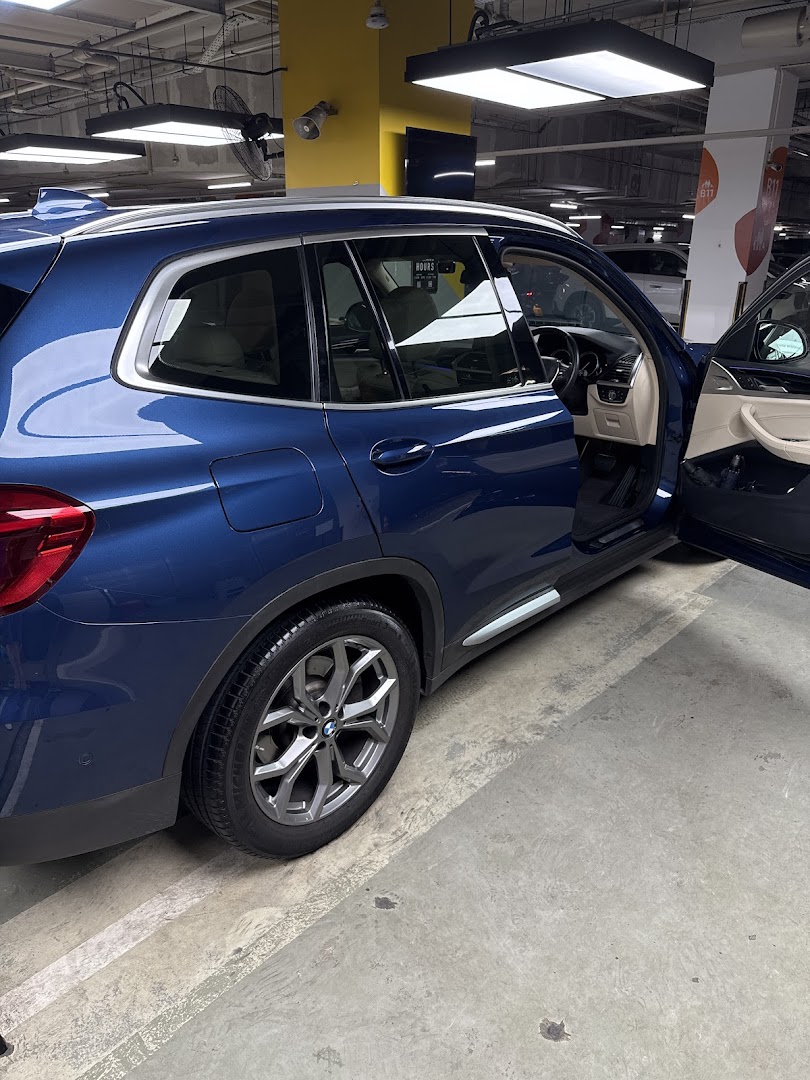 A blue BMW SUV parked in a car detailing bay at CARs International.