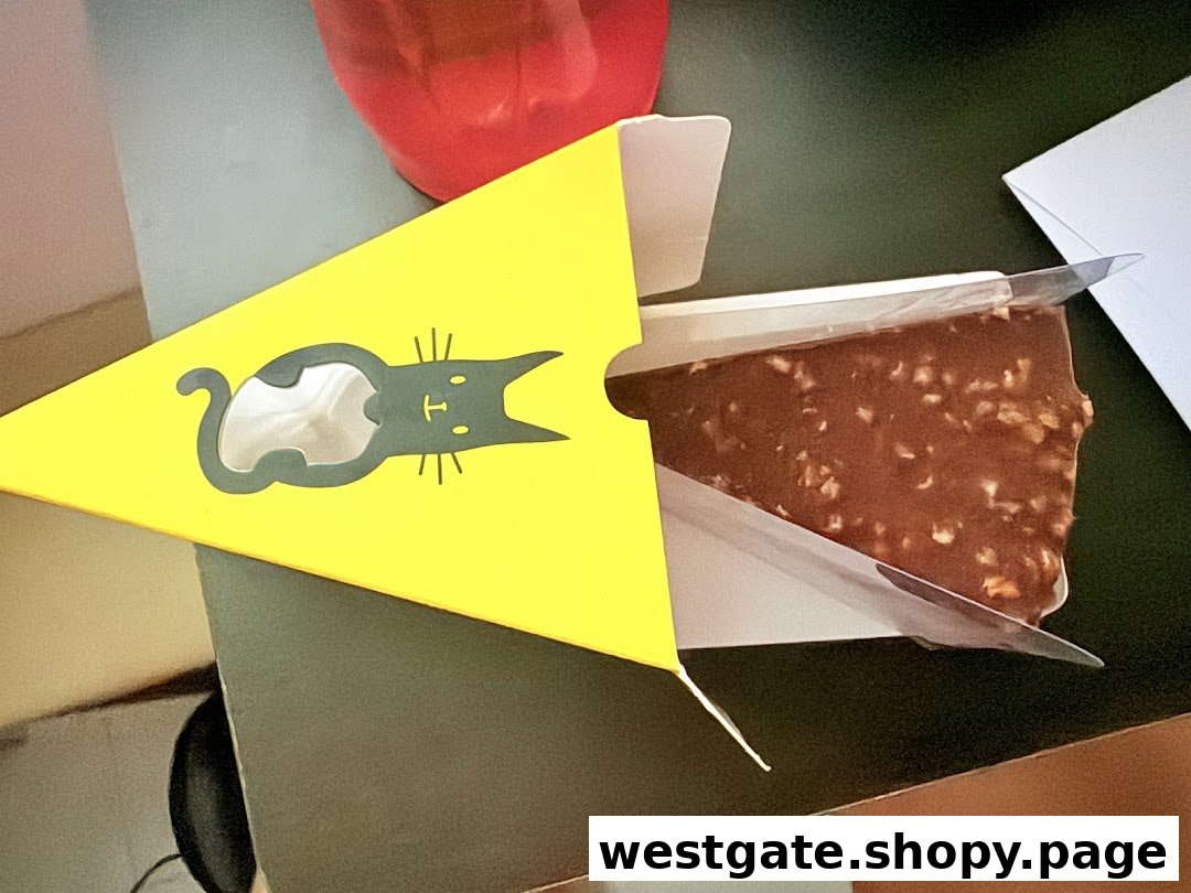 A delicious chocolate cake slice with nuts, presented in a distinctive yellow box with a cat logo.