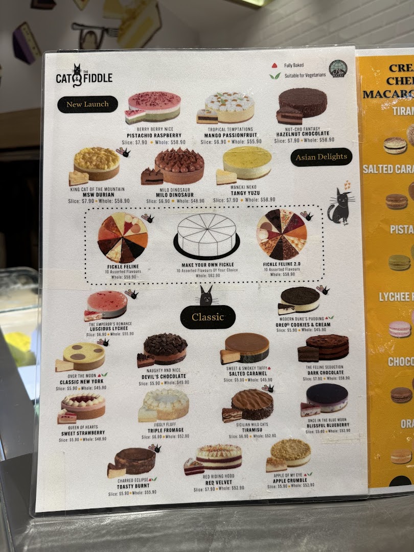 A detailed menu board from Cat & the Fiddle Cakes, showcasing various whole and sliced cheesecakes.