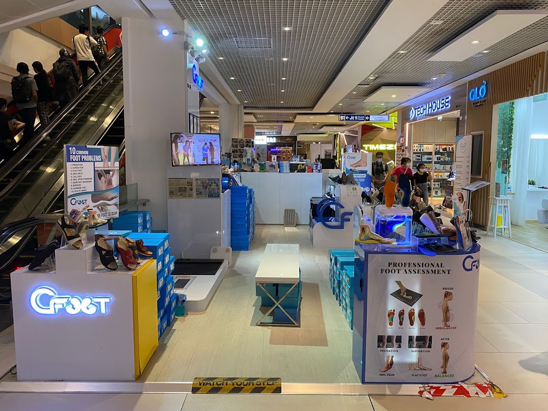 An interior view of CFOOTWestgate, a foot care shop, featuring foot assessment stations and products, located next to an escalator.
