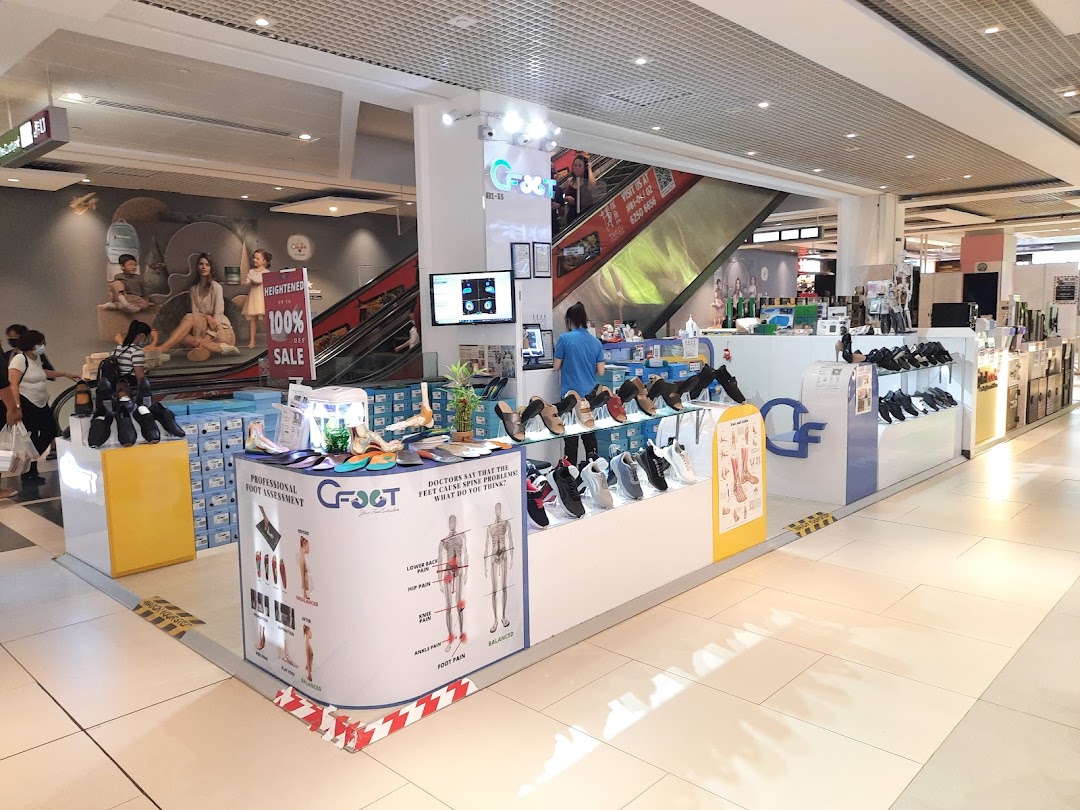 Interior view of C-FOOT kiosk displaying shoes, foot assessment services, and a staff member.