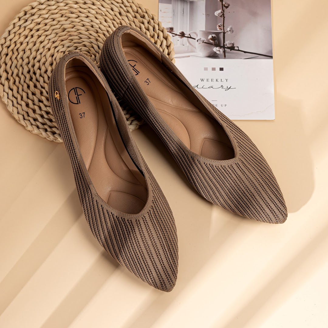 A pair of stylish brown knitted ballet flats with pointed toes, displayed on a light background.