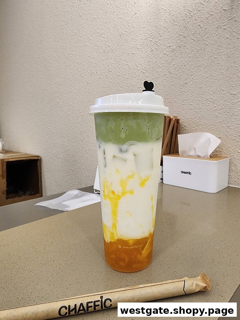 A vibrant, layered beverage from Chaffic, featuring green, white, and orange hues, on a counter.
