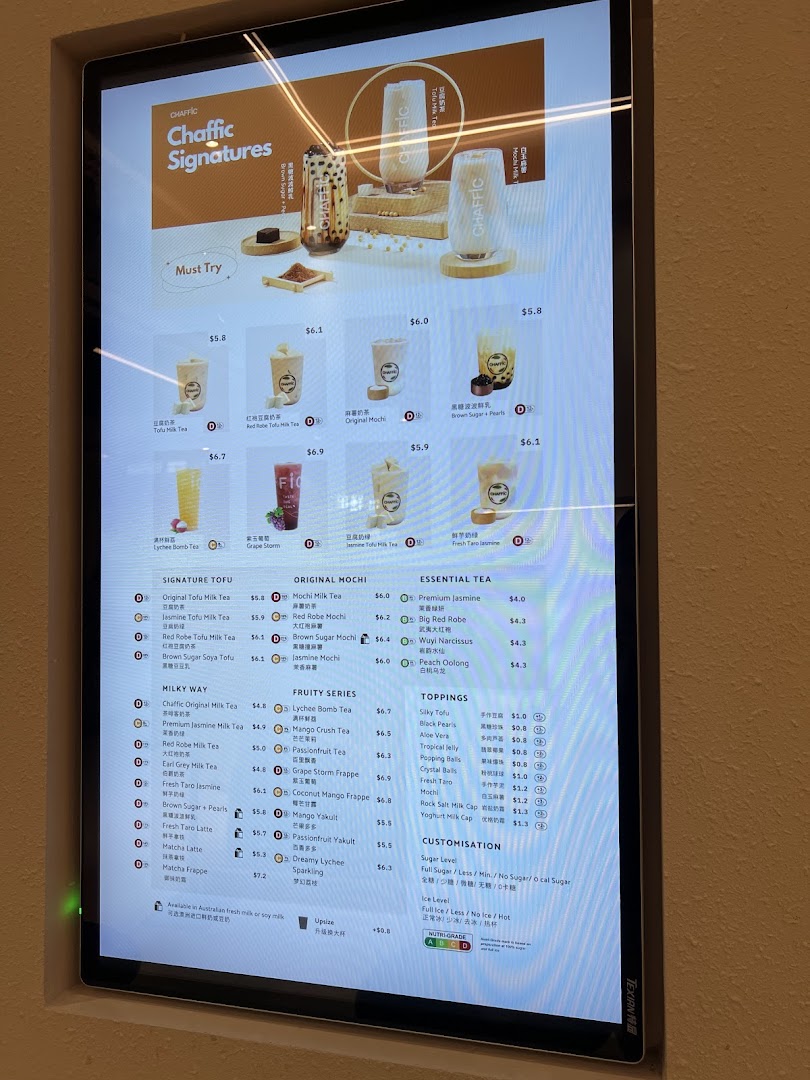 A digital menu board displaying various bubble tea and beverage options with prices and customization details.
