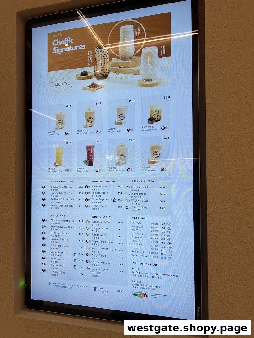 A digital menu board displaying various bubble tea and beverage options with prices and customization details.
