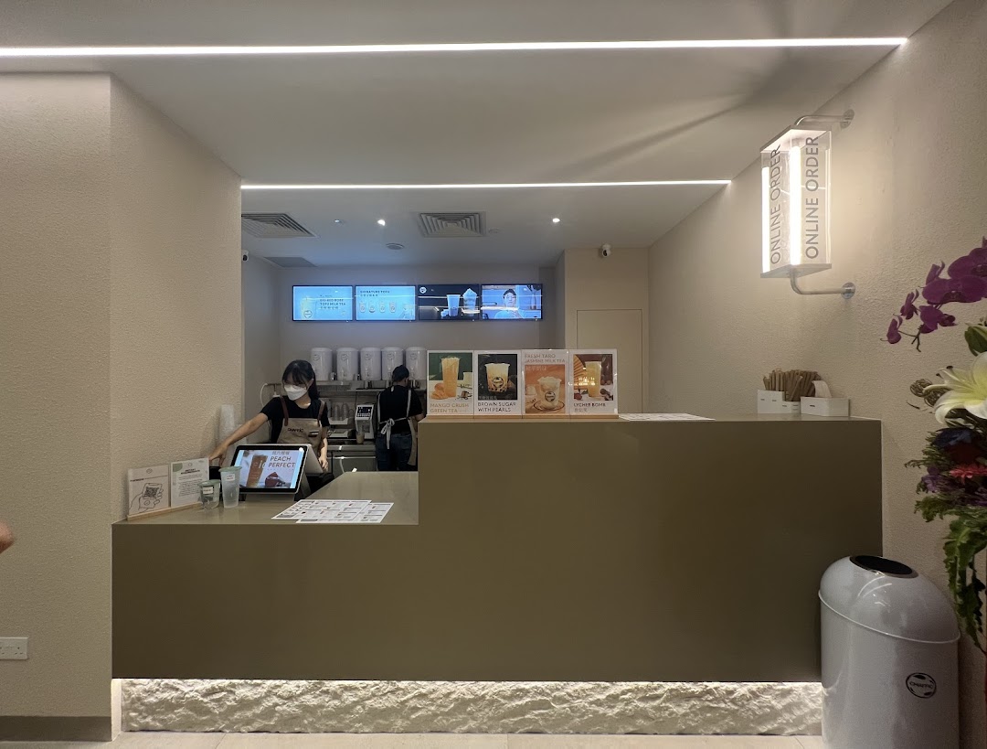 A staff member serves customers at the modern counter of Chaffic Westgate, showcasing their beverage offerings.