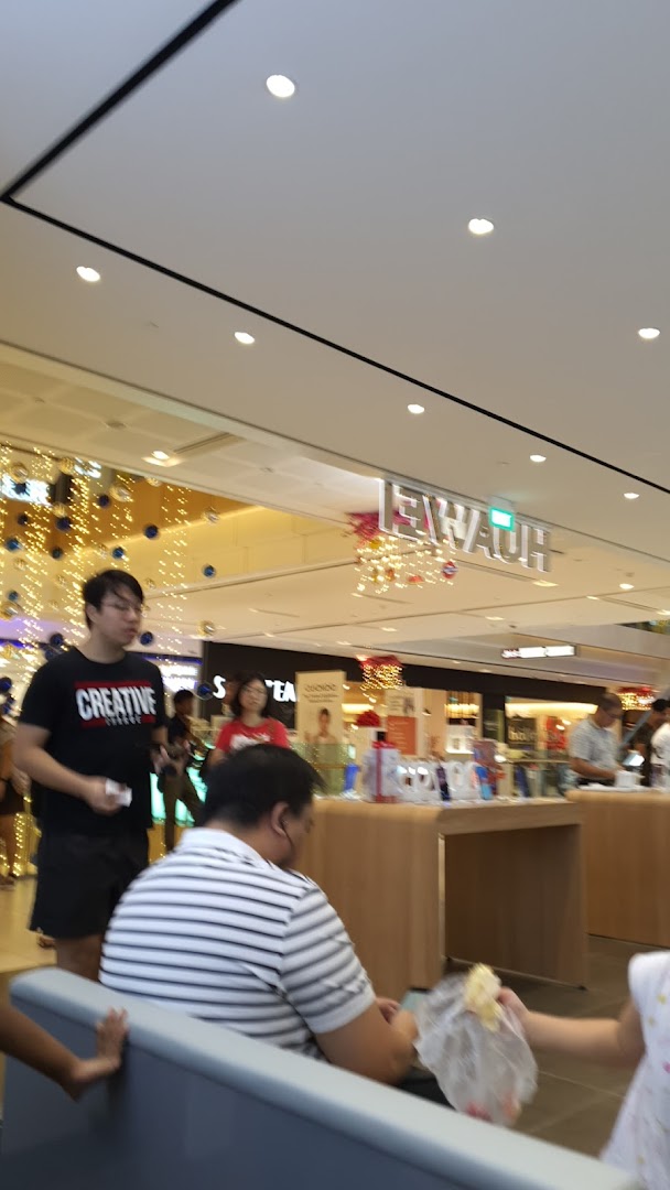 An interior shot of a shopping mall with shoppers and a Huawei electronics store in the background.