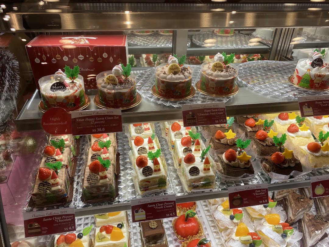 A vibrant display case showcasing Châteraisé's festive Christmas cakes and pastries.