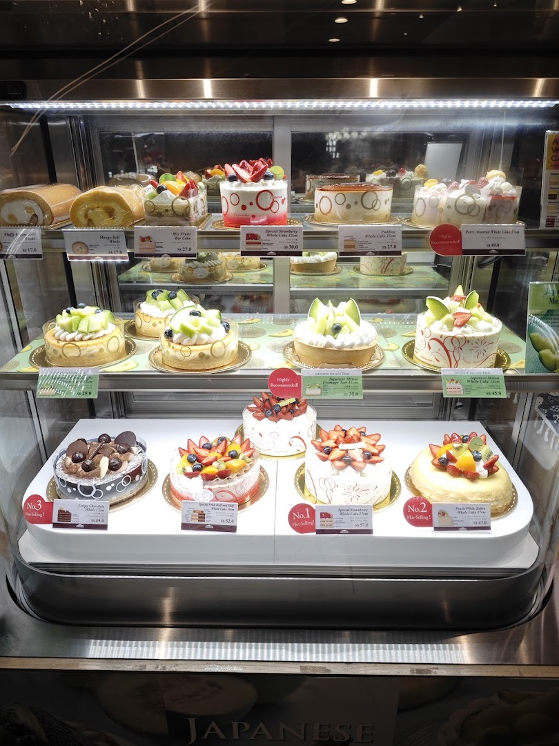 A vibrant display case showcasing a variety of beautifully decorated cakes and pastries at Châteraisé.