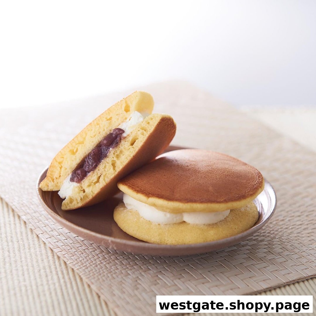 Two delicious dorayaki-style pancakes filled with sweet red bean paste and fresh cream on a plate.