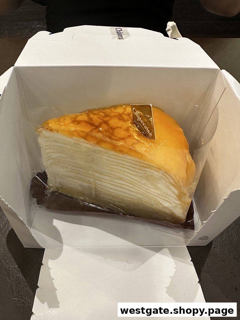 A delicious slice of multi-layered crepe cake from Châteraisé, presented in its take-out box.