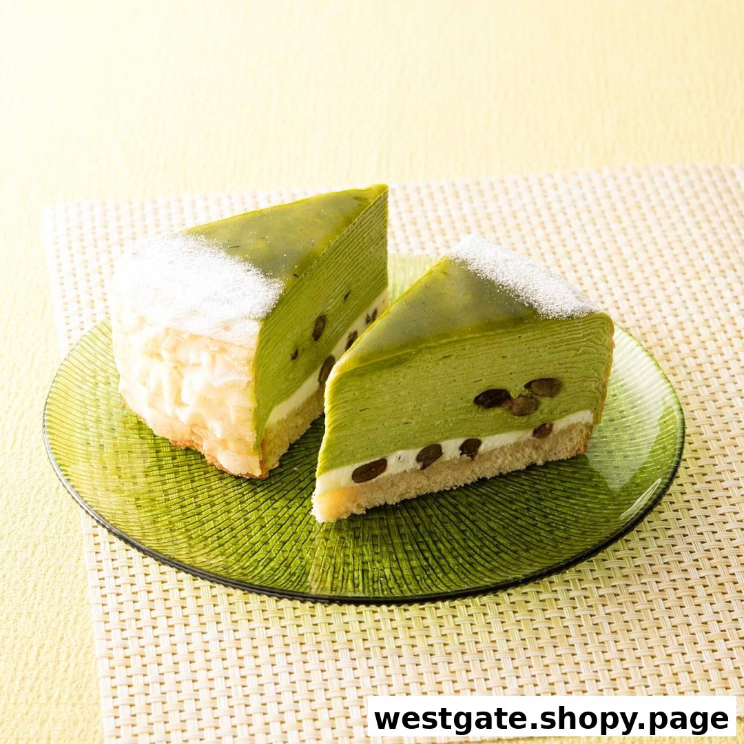Two slices of vibrant green matcha cake with red beans and cream on a green glass plate.