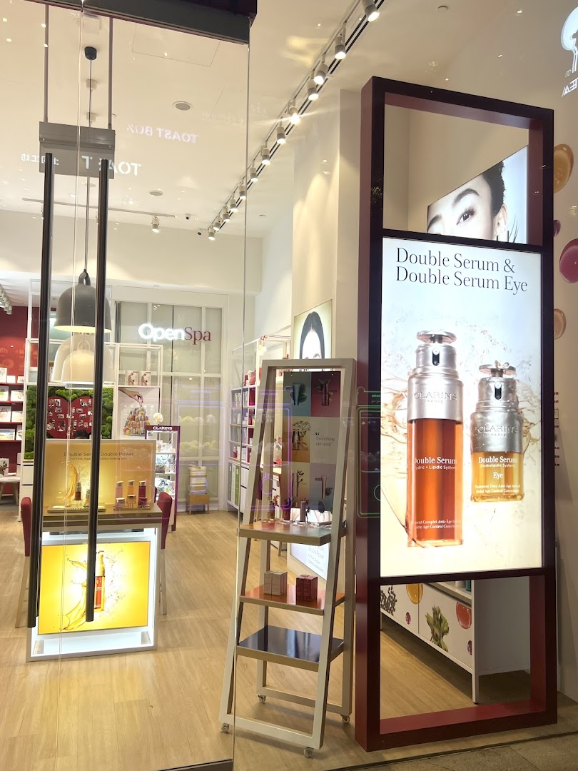 Entrance of Clarins Boutique showcasing skincare products and an 'Open Spa' area.