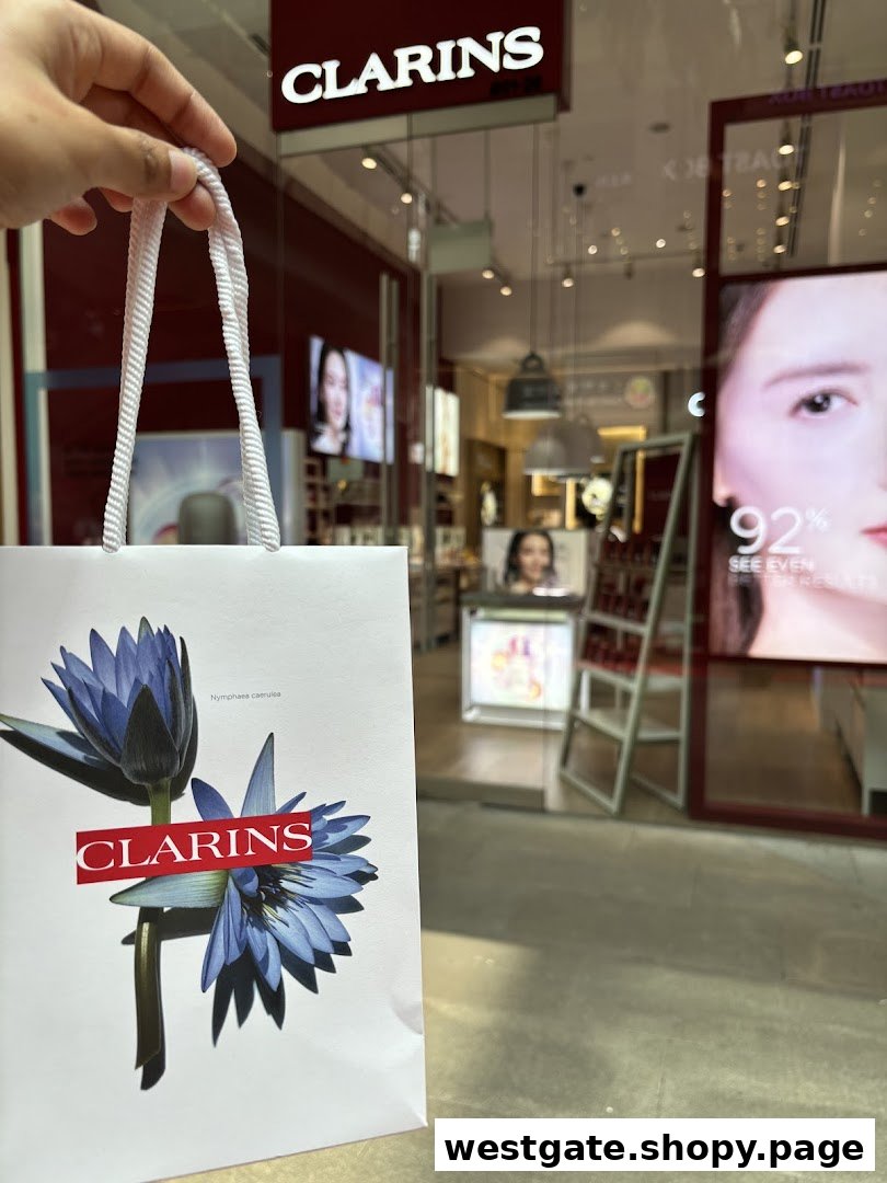 A hand holds a Clarins shopping bag in front of the Clarins boutique entrance at Westgate.